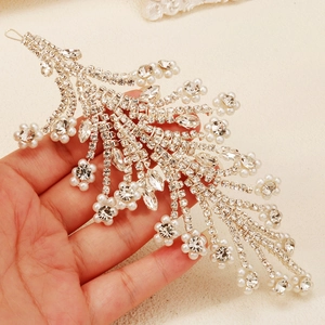 Close-up of bridal headpiece featuring silver leaf branches with rhinestones and pearls
