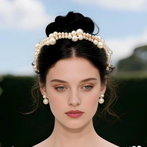 Detailed set of bridal pearl headband and stud earrings on model for a wedding look