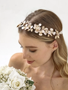 Dettaglio di fiori rosa con perle bianche e foglie in metallo dorato su fascia da sposa