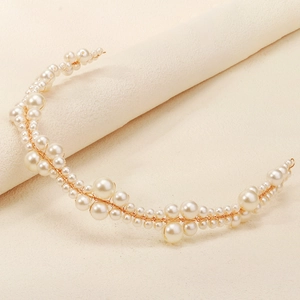Close-up of elegant handmade bridal headband with pearls and delicate gold wire wrap