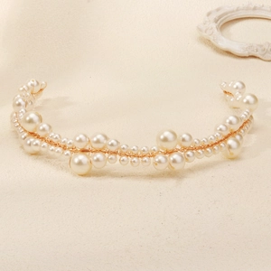 Detail of handcrafted bridal headband with various sized white pearls on gold wire