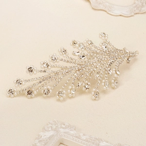 Elegant bridal feather hair accessory with rhinestones and pearls on a beige background