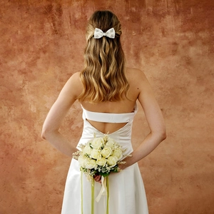 Détail d'un nœud papillon en satin blanc avec strass pour coiffure de mariée élégante