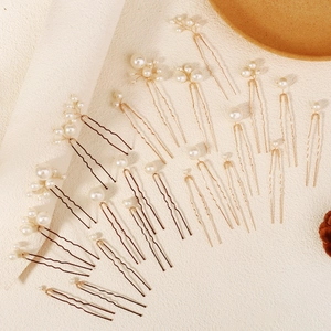 Vue détaillée d'épingles à cheveux de mariée en U avec perles blanches en doré et café