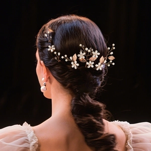 Detail of bridal hair comb with pearls and rose gold leaves on brunette hair