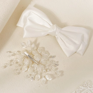 Détail d'un nœud de mariée en satin blanc avec perles et pince à fleurs faite main