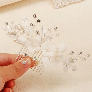 Détail du peigne à cheveux mariée avec fleurs blanches, perles et strass argentés