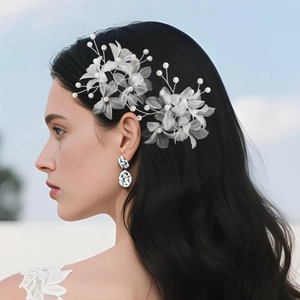 Detail von Braut-Haarnadel mit weißen Tüllblüten, Perlen und silbernen Edelsteinohrringen