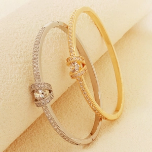 Detailed close-up of gold and silver ocean series bangles with zircon and shell buckle