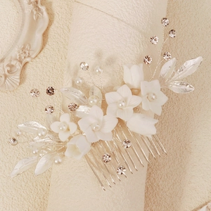 Détail du peigne à cheveux de mariée avec fleurs en céramique, perles et feuilles argent