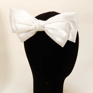 Gros plan sur le nœud papillon de mariée en satin blanc avec texture soyeuse