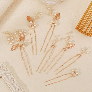 Detail of handmade bridal hair pins with golden leaves, pearls and crystal beads