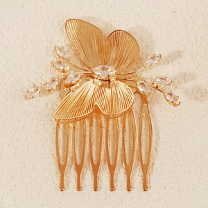 Macro shot of gold butterfly hair comb with sparkling crystals and fine wire textures