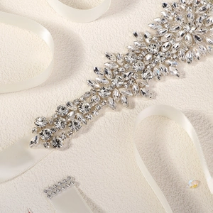 Detailed macro view of luxury bridal belt featuring sparkling rhinestones on white satin ribbon