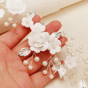 Exquisite bridal hairband with white clay flowers, silver leaves, and pearls for weddings