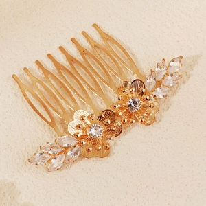 Detail of bridal hair comb with gold floral motifs and marquise-cut rhinestones