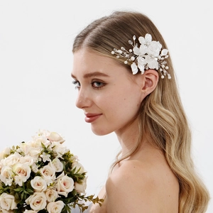 Detail showing white silk flowers and crystal beads on a bridal hair comb
