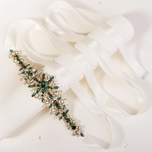 Detail of bridal belt featuring emerald and clear rhinestones on ivory satin ribbon