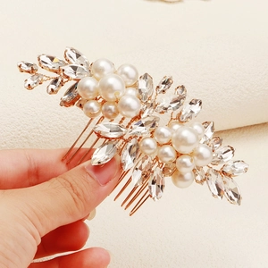 Detailed close-up of bridal hair comb with gold plating, white pearls and marquise rhinestones