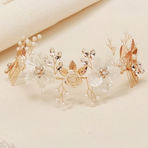 Detail of bridal hair comb with acrylic flowers, faux pearls and golden leaves on fabric