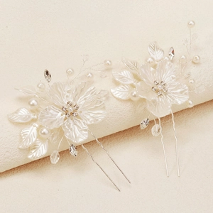 Detailed macro view of white shell flower bridal hair pins with pearls and crystals