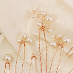 Détails de pics à cheveux en perles artisanales sur un tissu en soie dorée