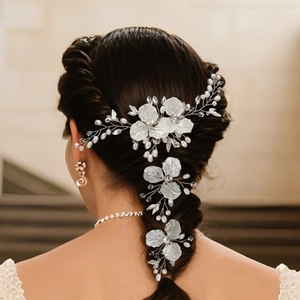 Detailed close-up of bridal white floral hair pins with pearls and crystal vine on hair