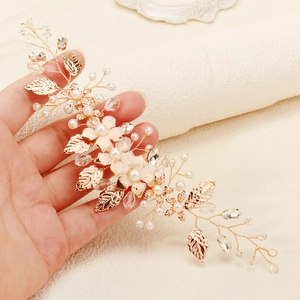 Detailed close-up of handmade bridal headband with white flowers and gold leaf accents