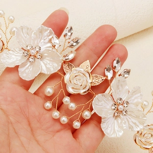 Macro shot of bridal hair comb featuring acrylic flowers and white pearl beadwork