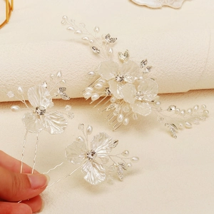 Detailed view of handmade bridal hair comb set with white resin flowers and crystals