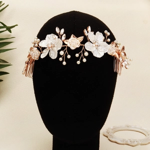 Elegant bridal hair comb with white acrylic flowers, pearls, and crystals on a gold wire base