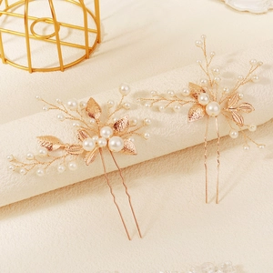 Détail d'épingles à cheveux de mariée avec feuilles dorées et perles blanches faites main