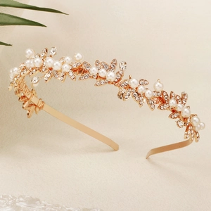 Detail of golden bridal headband with white pearls and sparkling crystal leaf pattern