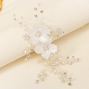 Detailed view of handmade bridal hair comb with white silk flowers and pearl beads
