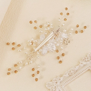 Detailed close-up of handmade bridal hair comb with white acrylic flowers and pearls