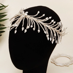 Coiffe de mariée argentée étincelante avec design en plumes de strass sur un mannequin