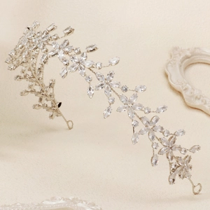 Dettaglio della fascia da sposa con zirconi scintillanti e cristalli argentati a foglia