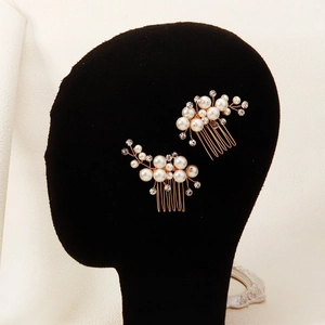 Détail de peignes à cheveux de mariée en or rose avec perles et strass sur modèle