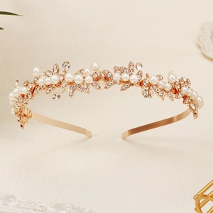Elegant gold bridal headband with sparkling rhinestones and white pearls in leaf design