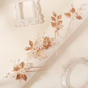 Macro detail of rose gold leaf hair comb and pearl hairpins for bridal styling