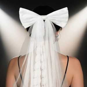 Detail of elegant white satin bow with a long single-layer sheer wedding bridal veil