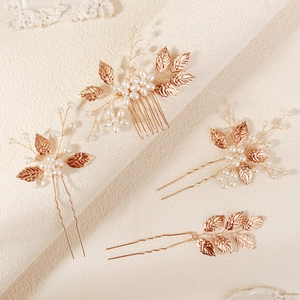 Macro shot of gold leaf bridal hair pins with pearls and handmade wire craftsmanship