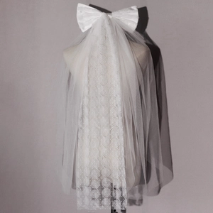 Elegant white bridal veil with large satin bow and floral embroidery for weddings