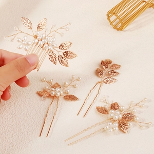 Close-up of golden leaf and pearl bridal hair pins and comb wedding jewelry set