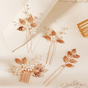 Detail of four-piece gold leaf and pearl bridal hair comb set with intricate wire wrapping