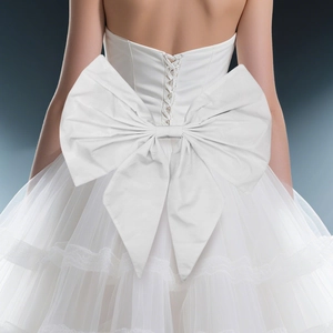 Detail of the large white satin bow and cross-tie back on the lace bridal gown
