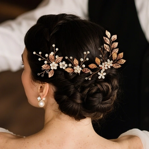 Bridal hair set with golden leaves and pearls on dark braided hair for wedding