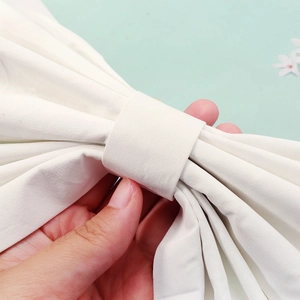 Close-up of white fabric bridal bow detailing the layered fold and central knot structure