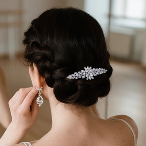 Detail of silver bridal hair clip and teardrop earrings with sparkling zircons on model