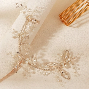 Détail d'un bandeau de mariée avec perles blanches, cristaux et feuilles argentées ciselées